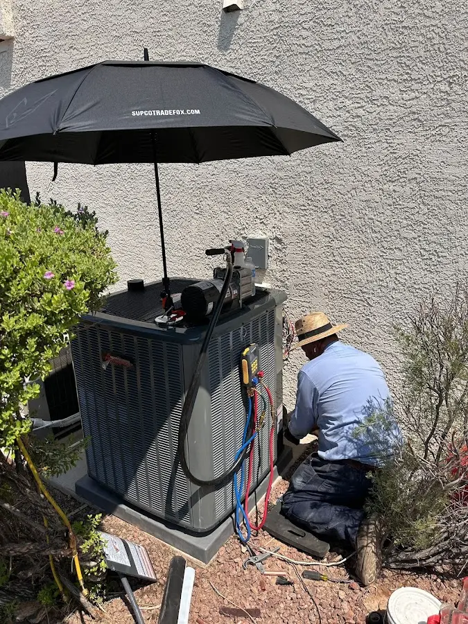 HVAC technician performing outdoor AC maintenance in Greenfield